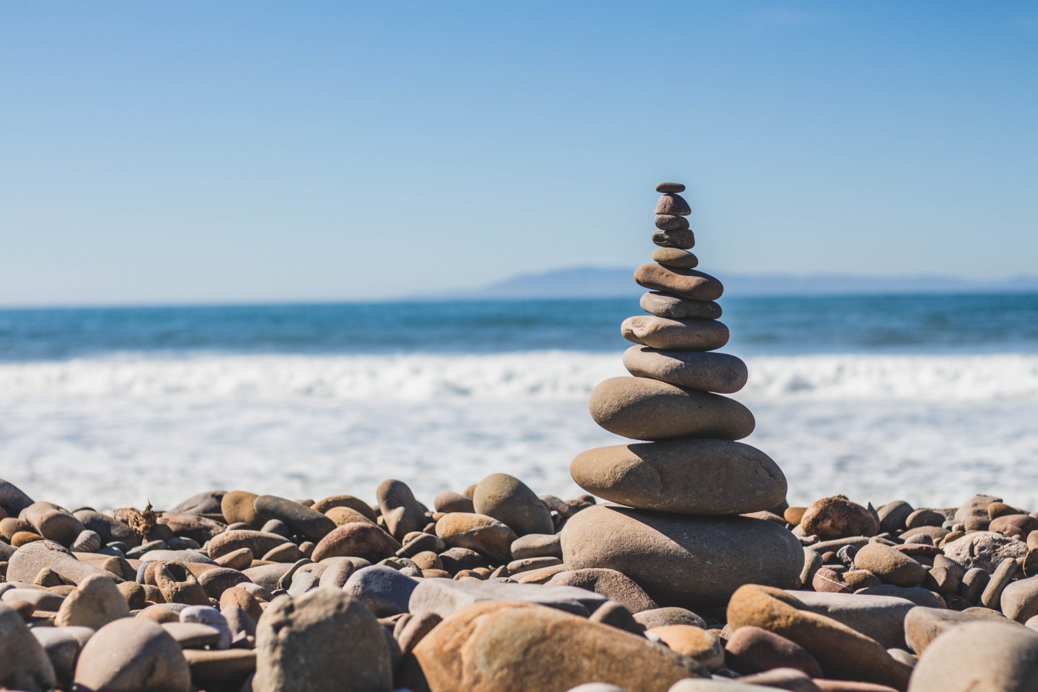 Stacked rocks at beach | Abundant Life & Wellness | Integrative Health Practitioner for chronic illnesses and Lyme Disease